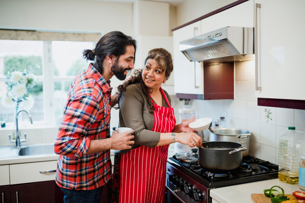 A person standing in a kitchen preparing food

Description automatically generated