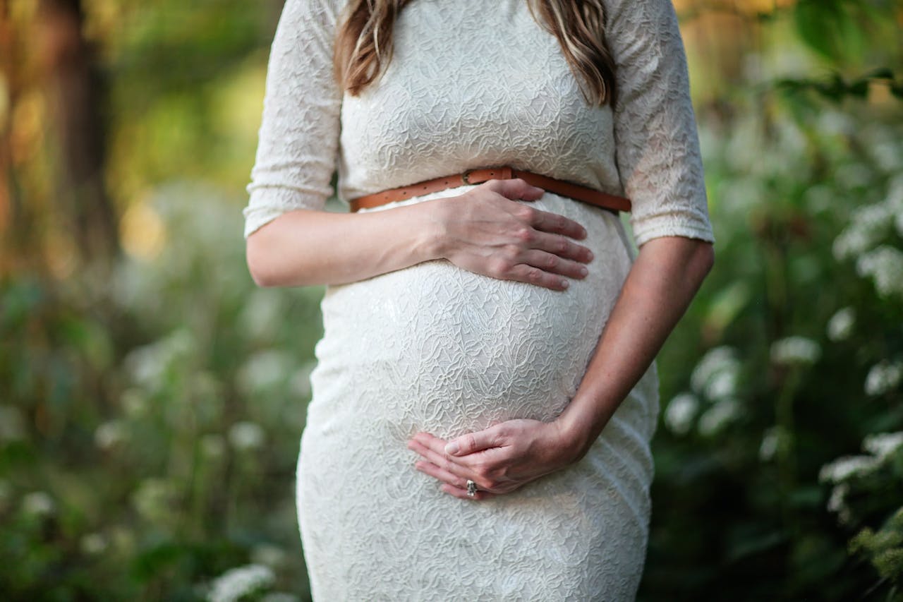 A pregnant person holding her belly Description automatically generated