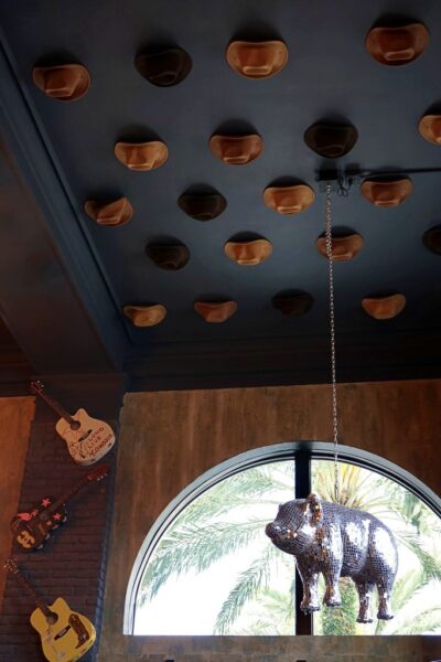 A disco pig, cowboy hats on the ceiling, and guitars on the wall… because subtle was never the goal.