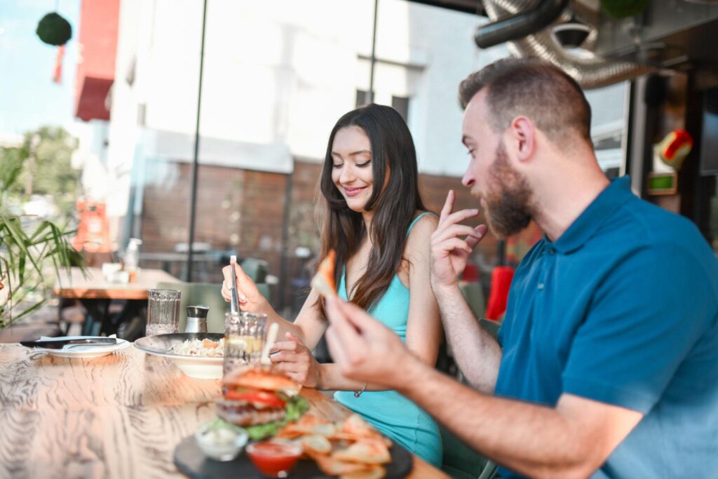 Split image of a couple showing contrasting lifestyles, one side fine dining and dressed up, the other casual with a burger, representing relationship gaps in modern dating