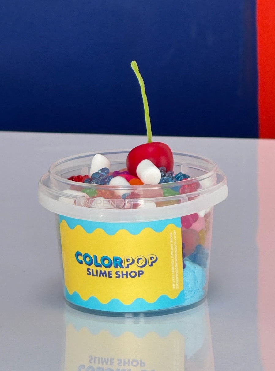 Close-up of a custom slime sundae from ColorPop Slime Shop with colorful toppings and cherry decoration.