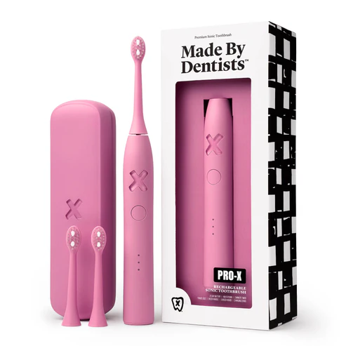 Made By Dentists PRO-X Sonic Toothbrush in pink with travel case and replacement heads, a dentist-designed sonic toothbrush for plaque removal and gum health.