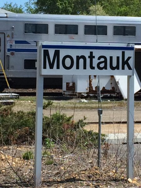 Montauk train station sign with LIRR train, Hamptons summer travel