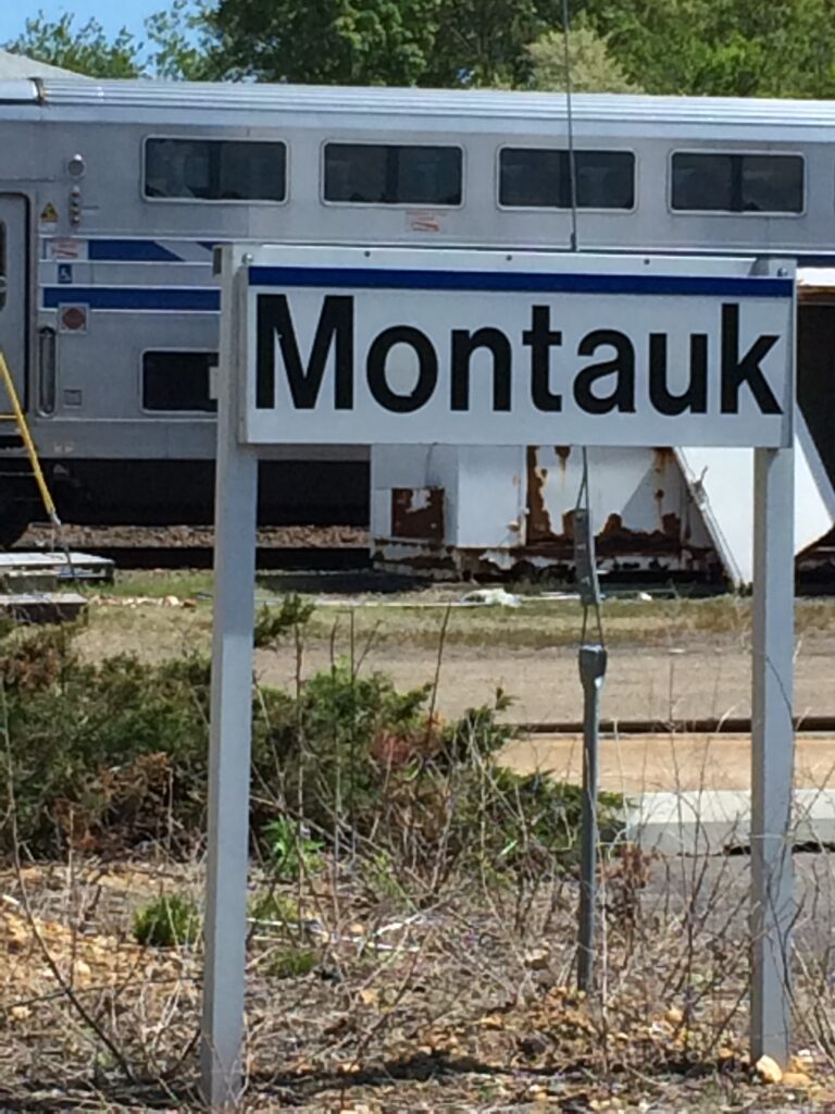 Montauk train station sign with LIRR train, Hamptons summer travel