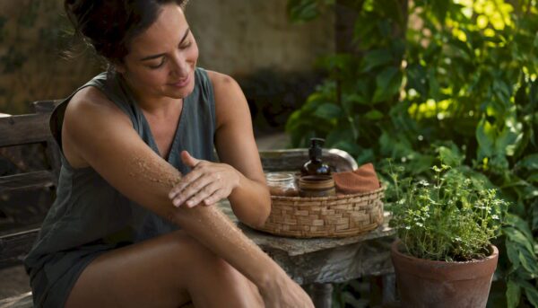 Woman applying sugar scrub on skin