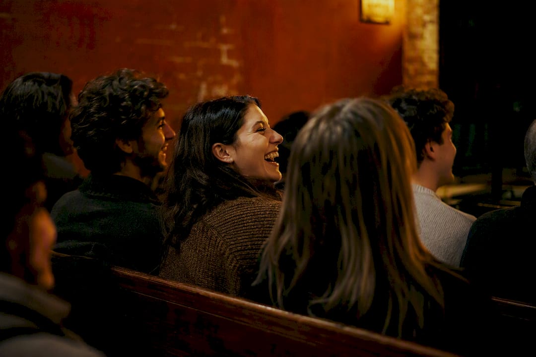 Friends laughing together in small theater