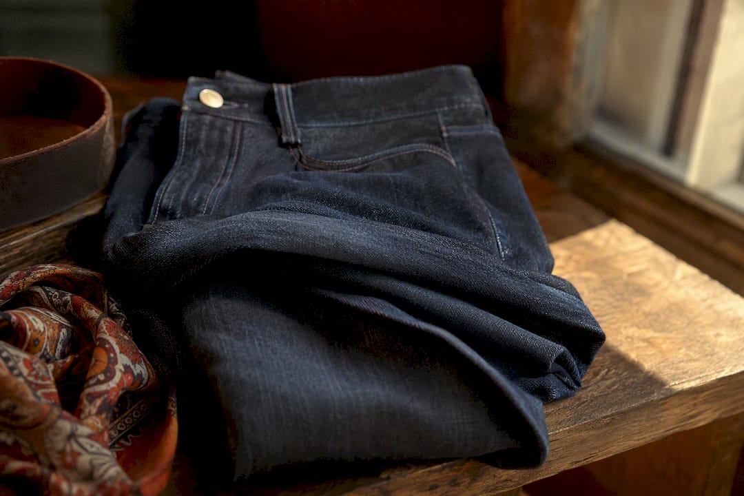 Dark slim jeans fabric texture on wood