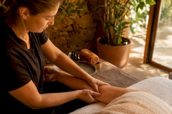 Hands performing lymphatic drainage massage on arm