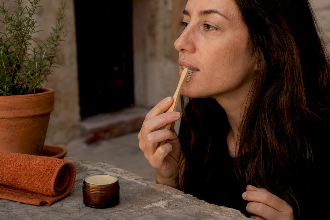 Hand exfoliating lips with toothbrush and balm