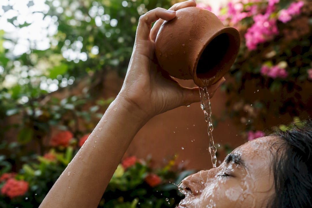 Woman splashing water on hydrated skin