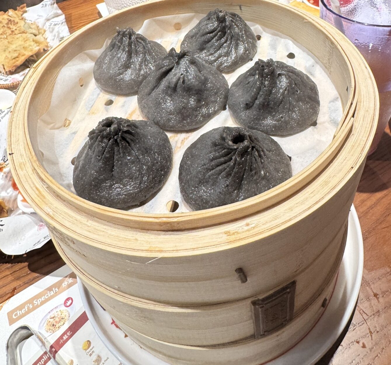 Black truffle soup dumplings in a bamboo steamer at Nan Xiang Soup Dumplings